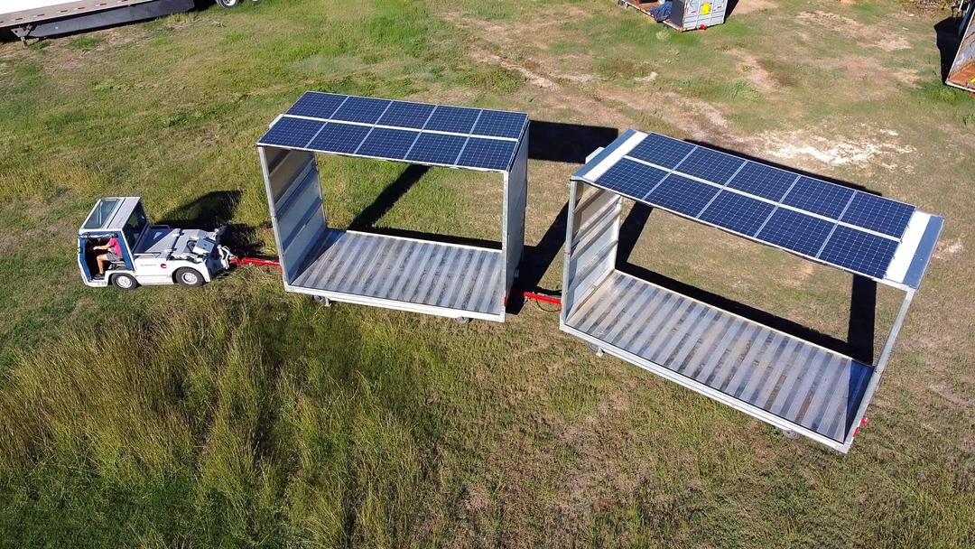 Aerial photo of an electric vehicle with 2 trailers equipped with solar panels